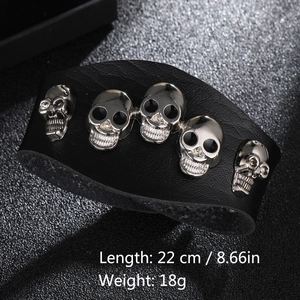 Detail eines breiten schwarzen Punk-Lederarmbands mit fünf silbernen Totenköpfen und Maßen