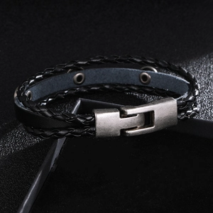 Détail d'un bracelet en cuir noir tressé avec étoiles et fermoir en métal au style vintage
