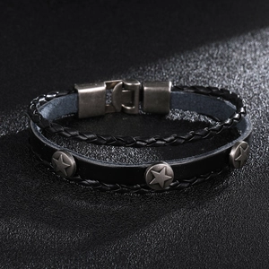 Détail d'un bracelet en cuir noir avec trois rivets étoiles et un fermoir métallique