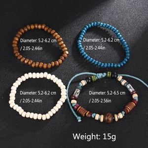 Detail view of four vintage multi-layer wooden bead bracelets on black leather background