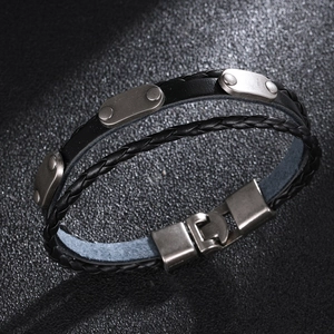 Detail of men's leather bracelet with woven cord, vintage silver plate and metal clasp