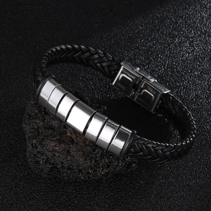 Macro detail of men's braided leather bracelet with polished stainless steel cylinders