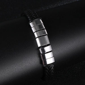 Detailed close-up of men's braided leather bracelet with polished steel metal accents