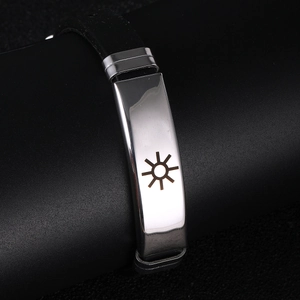 Detailed macro view of black silicone bracelet featuring a polished silver sun pattern plate