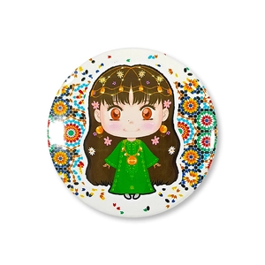 Close-up of circular tinplate badge with cartoon girl illustration and floral patterns