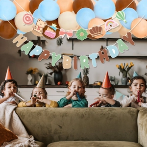 Birthday party set with pastel balloons, cake bear banner and kids celebrating