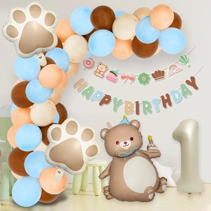 Close-up of birthday party kit with cake bear foil balloon and happy birthday banner