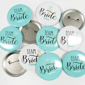 Detail of Team Bride button badges showing glossy finish and safety pin back