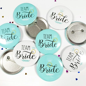 Detail of Team Bride tinplate badges with diamond ring graphic for wedding parties