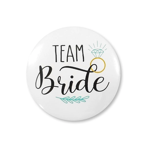 Detail of round tinplate badge featuring Team Bride text and a diamond ring illustration