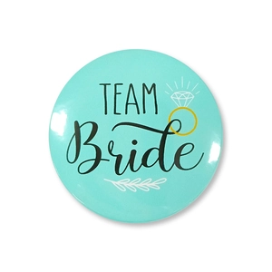 Close-up of mint green Team Bride badge with gold diamond ring and leaf decorations