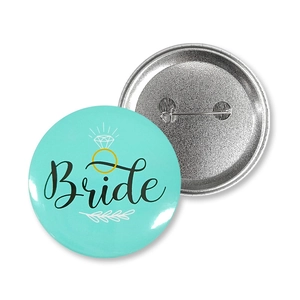 Macro view of mint green tinplate wedding badge with Bride text and safety pin back