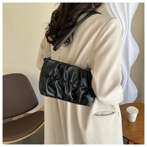 Détail du sac à bandoulière noir plissé en similicuir avec boucles métalliques argentées