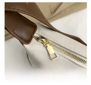 Macro view of golden zipper detail and precise stitching on retro cream shoulder bag