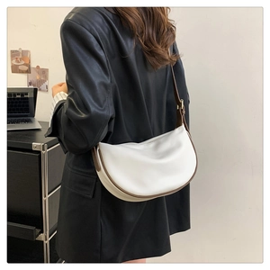 Detail of white leather hobo bag with brown strap and gold buckle on a model