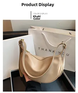 Detail view of khaki crescent shoulder bag with smooth synthetic leather and gold hardware