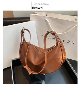 Detailed view of a brown semi-circular PU leather hobo bag with sleek gold zipper closure
