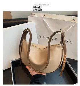 Detail view of the khaki hobo shoulder bag with dark brown strap and zipper closure