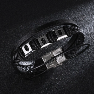 Macro detail of men's multilayer black braided leather bracelet with stainless steel buckle