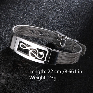 Detail of adjustable silver mesh steel bracelet with musical note charm on black stone