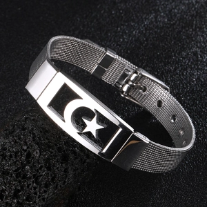 Macro detail of silver stainless steel mesh bracelet featuring a star and moon cutout plaque