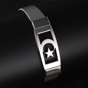 Close-up of silver mesh bracelet featuring a rectangular plate with star and moon cutouts