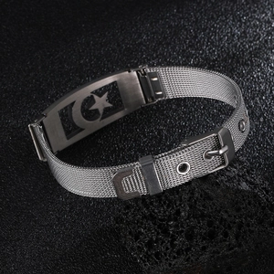 Detail of silver mesh steel bracelet featuring moon and star charms with pin buckle