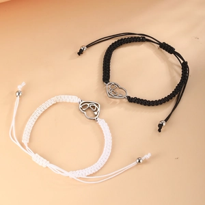 Detailed close-up of woven couple bracelets with heart and stethoscope metal charms