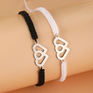 Detail of hand-woven black and white friendship bracelets with double heart pendants