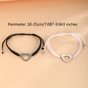 Detail of adjustable heart charm woven bracelets in black and white for couples
