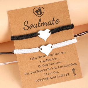 Detail of couple woven bracelets with heart charms and Soulmate sentiment card