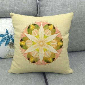 Close-up of linen-style pillowcase with geometric mandala pattern on a grey sofa