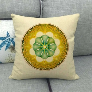 Close-up of linen pillowcase with green mandala pattern on a gray sofa fabric