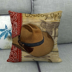 Detail of vintage cowboy hat design on linen pillow cover with red paisley pattern