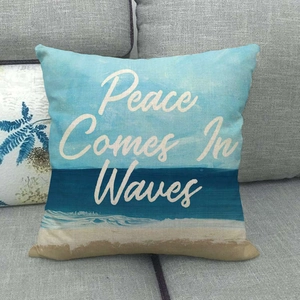 Detail of linen pillowcase with beach landscape and 'Peace Comes In Waves' quote text