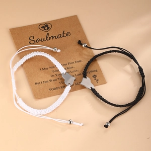 Matching couple braided bracelets with heart pendants on a soulmate gift card