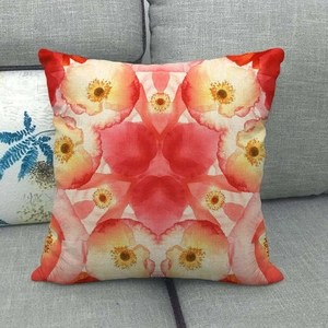 Detail of red floral linen pillowcase showing geometric poppy pattern on gray sofa
