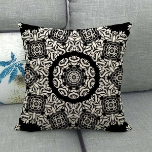 Linen decorative square throw pillow with black and white mandala patterns on a sofa