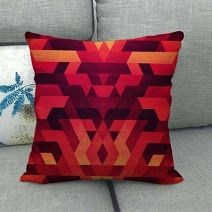 Detail of linen cushion cover featuring red abstract geometric pattern on a sofa
