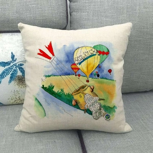 Detail der Leinen-Kissenhülle mit Heißluftballon und Bonjour-Text auf grauem Sofa