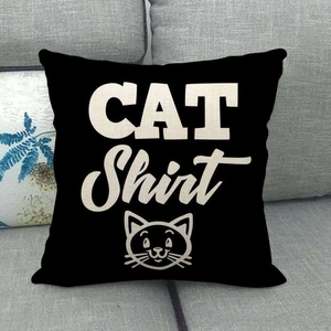 Detail of black linen pillow cover with white cat shirt print on a grey sofa