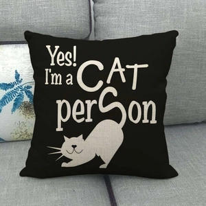 Linen cushion cover with black cat print and 'Yes! I'm a CAT person' text on a gray sofa