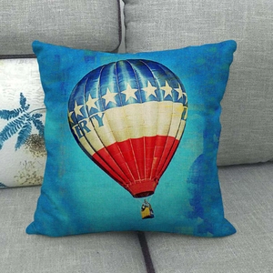 Leinen-Kissenbezug mit blauem Liberty-Heißluftballon-Motiv auf einem grauen Sofa