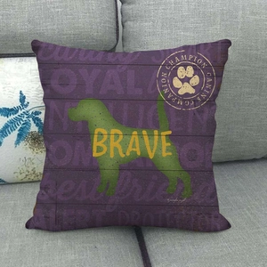 Détail d'un coussin en lin violet avec silhouette de chien verte et texte Brave imprimé