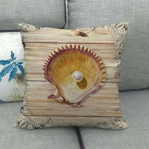 Detailed view of linen cushion cover with ocean shell print on a grey sofa