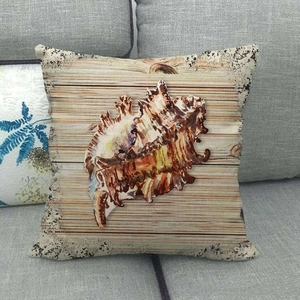 Detailed view of sea shell linen pillowcase featuring wood texture on a grey sofa