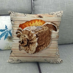 Close-up of linen cushion cover featuring a vintage conch shell print on wood background