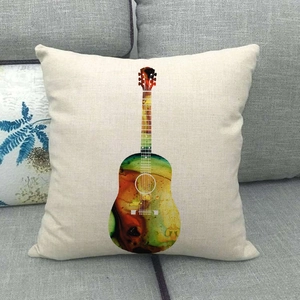 Detalle de funda de cojín de lino con diseño de guitarra acuarela en un sofá