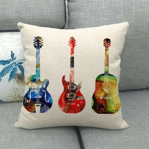 Funda de cojín de lino con motivos de guitarras de colores en un sofá gris