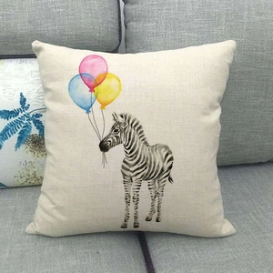 Detail of linen cushion cover showing zebra and colorful balloon print on gray sofa
